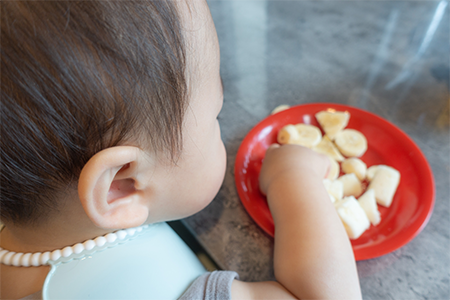 手掴みで離乳食を食べる子ども